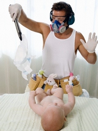 Father Changing Baby's Diaper --- Image by © Paul Barton/Corbis